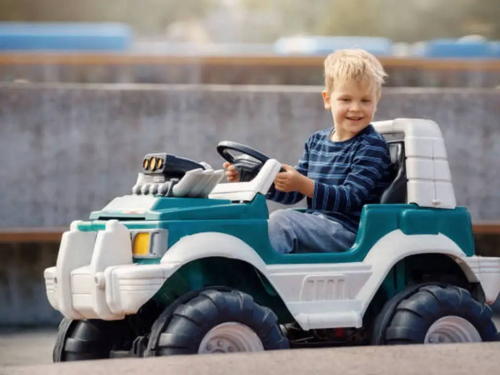 Un garçon joue avec des véhicules 24V