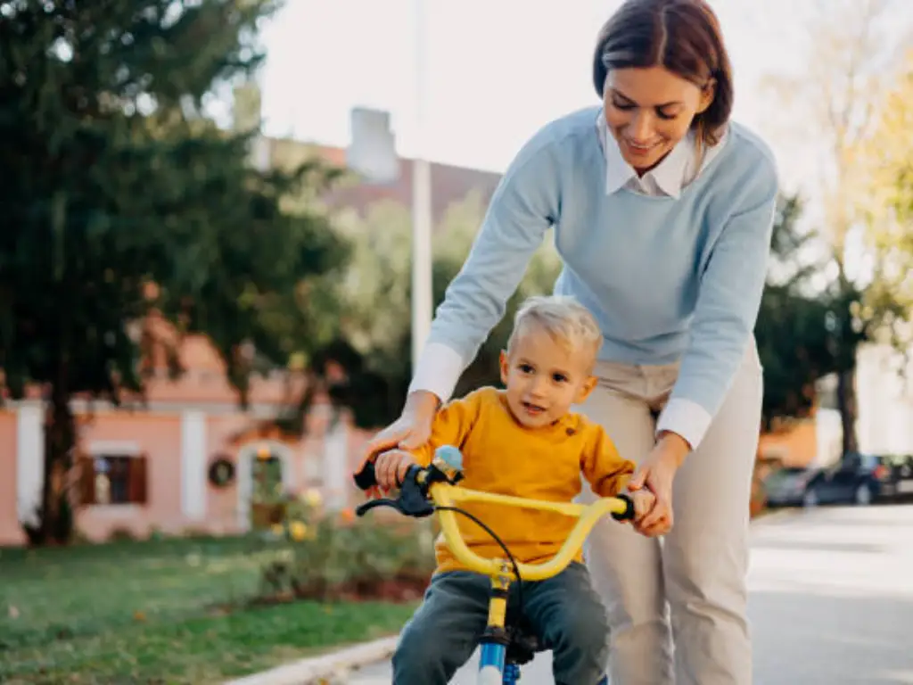 una madre enseña a su hijo a montar en bicicleta